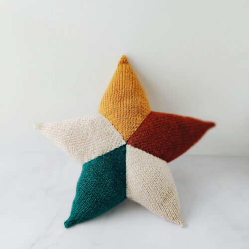 knitted star cushion in off white, teal, rust and golden yellow