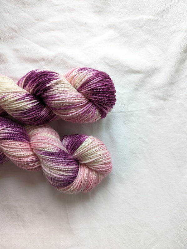Close up of skeins of hand painted DK yarn in purple and pink