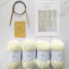 baby blanket knit kit contents featuring 4 balls of white yarn, needle and instructions