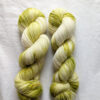 Two skeins of speckled olive green fingering weight yarn