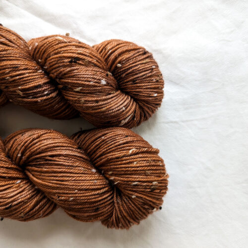 Close up of two skeins of chestnut brown tweed DK yarn