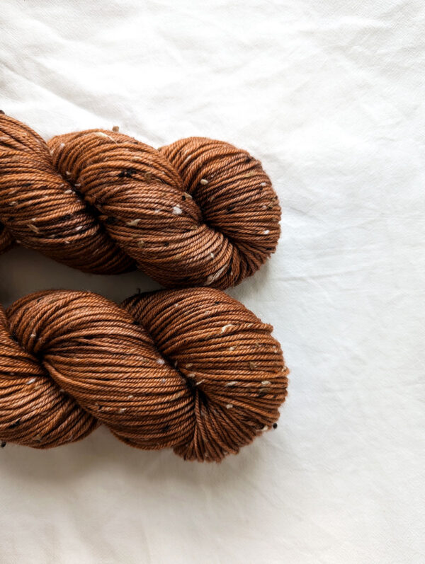 Close up of two skeins of chestnut brown tweed DK yarn