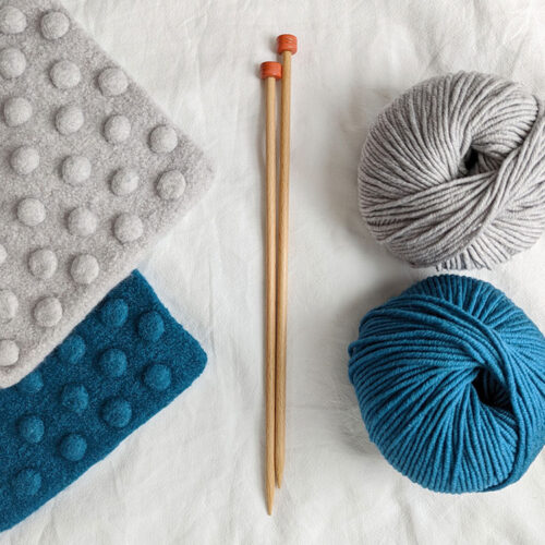 Felted potholder knitting kit contents with straight needles and teal or grey yarn