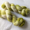 Two skeins of hand dyed yarn in fingering weight in olive green