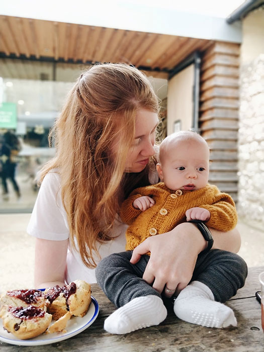 Emma from The Old Horizon with baby wearing knitted raglan cardigan.