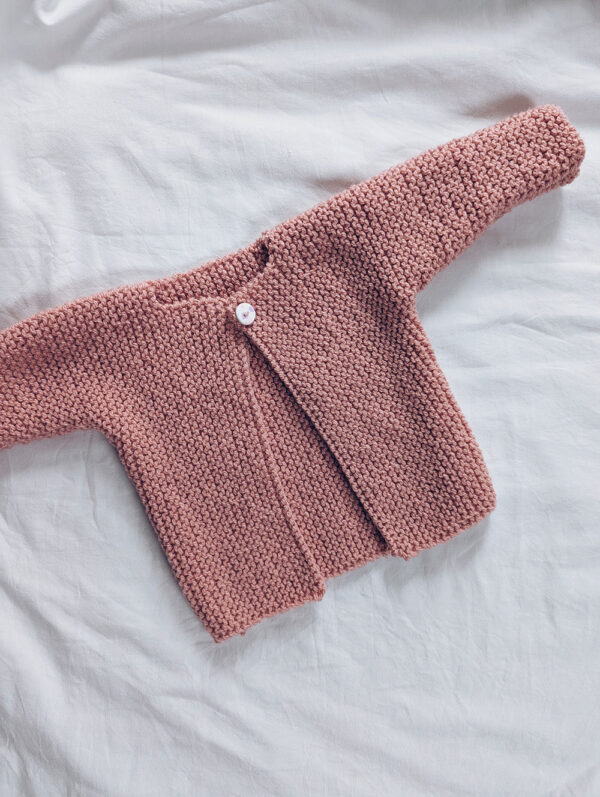 Baby aran cardigan from a knitting pattern featuring garter stitch