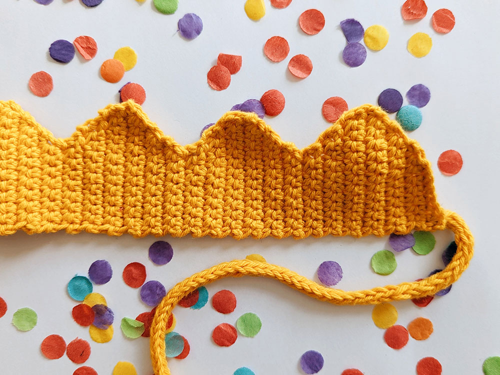 Crochet coronation crown in yellow cotton yarn with i-cord ties