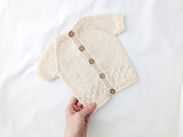 Short sleeve baby cardigan with raglan shaping and slipped stitch pattern